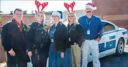  ?? WILLIAM HARVEY/THREE RIVERS EDITION ?? Cabot Police Department Capt. Brent Lucas, from left, resource officer Brittany Tauton, chaplain Tina Frost, dispatch lead Teresa Young and Lt. Robby Gibson pose in front of a police car. The Cabot Officers Playing Santa Toy Patrol, or C.O.P.S. Toy...
