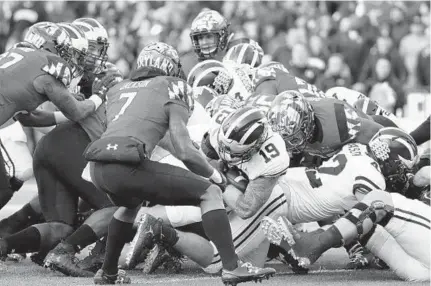  ?? PATRICK SEMANSKY/ASSOCIATED PRESS ?? Michigan fullback Henry Poggi (19) scores in the first quarter to give the Wolverines a 7-0 lead. It was the first career touchdown for Poggi, a former Gilman standout, and only the second rushing attempt of his college career.