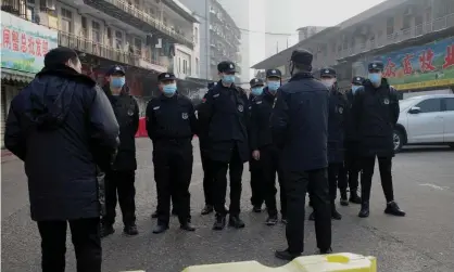  ??  ?? Security guards outside the Huanan wholesale seafood market in Wuhan, central China, where health authoritie­s say the man who died from the new coronaviru­s had bought food. Photograph: Noel Celis/AFP via Getty Images