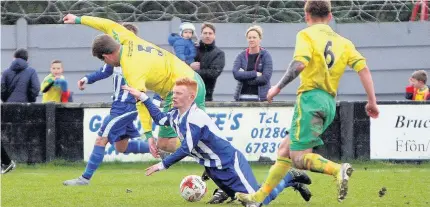  ??  ?? Holyhead’s Jamie Roberts (blue) takes a tumble against Town’s Grahame Austin.