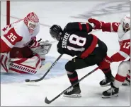  ?? ADRIAN WYLD — THE CANADIAN PRESS VIA AP ?? Detroit Red Wings defenseman Filip Hronek chases Ottawa Senators left wing Tim Stutzle as he shoots the puck at Red Wings goaltender Ville Husso during the first period of Tuesday’s game in Ottawa, Ontario.