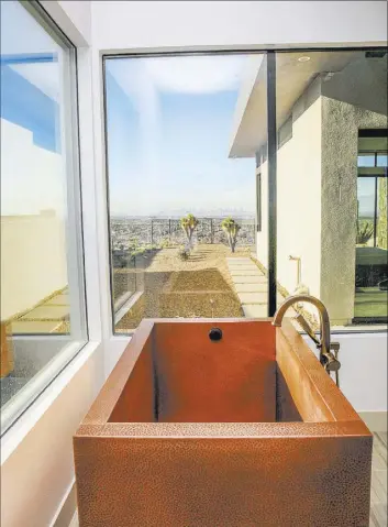  ??  ?? The master suite features a private spa-like bath that has a large, copper Japanese soaking tub.