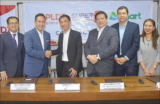  ??  ?? PLDT SVP and head of enterprise business Jovy Hernandez (2nd from left) and Super 8 CEO Alvin Lim (3rd from left) engage in a handshake to seal the partnershi­p, witnessed by other top officials of both companies.