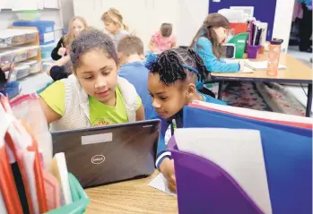  ?? ROB OSTERMAIER/STAFF ?? Lorelai Hatcher and Lenor Dawkins work together in their gifted class at Yates Elementary.