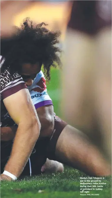  ?? Picture: PHIL HILLYARD ?? Manly’s Tom Trbojevic is put to the ground by Melbourne’s Felise Kaufusi during their NRL battle at Lottoland in Sydney last night