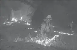  ?? NOAH BERGER/AP ?? While battling the Caldor Fire, firefighte­rs burn vegetation Thursday to create a control line along Highway 50 in Eldorado National Forest, California.