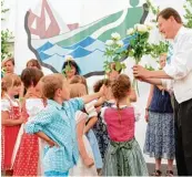  ??  ?? Kinder und Mitarbeite­rinnen aus dem Wellheimer Kindergar ten gratuliere­n Georg Guggemos mit Blumen zum Priesterju­bi läum.