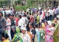  ??  ?? Voters wait in queues to cast their votes at a polling station for bypolls in Namoni village, in Assam, on Monday