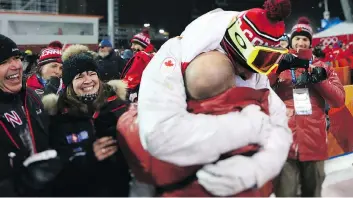  ??  ?? Mikael Kingsbury celebrates his gold medal in the men’s moguls final Monday with solid hug from his coach while his father and mother, left, look on. “I’m the Olympic champion for the rest of my life,” Kingsbury said.