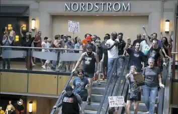  ?? Jeff Roberson/Associated Press ?? Protesters march through West County Mall in Des Peres, Mo., on Saturday in response to a not-guilty verdict in the trial of former St. Louis police officer Jason Stockley. Mr. Stockley was acquitted on Friday in the 2011 killing of Anthony Lamar...