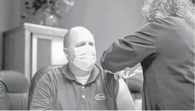  ?? MELISSA MELVIN/AP ?? A worker at a Tyson Foods meatpackin­g plant in Wilkesboro, North Carolina, receives a COVID-19 vaccine last month as part of a nationwide campaign. Last spring, major outbreaks at a number of meatpackin­g plants forced them to close temporaril­y.