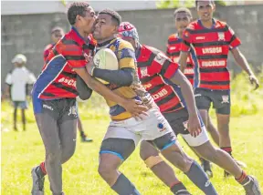  ?? Photo- Leon Lord ?? RKS forward Motikai Murry (right) takes on the Lomaivuna defence during the Vodafone Fiji Secondary Schools Rugby League match at St Marcellin Primary School ground in Vatuwaqa on the March 20, 2021.