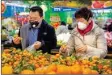  ?? People wear face masks as they shop for produce at a supermarke­t in Beijing ??