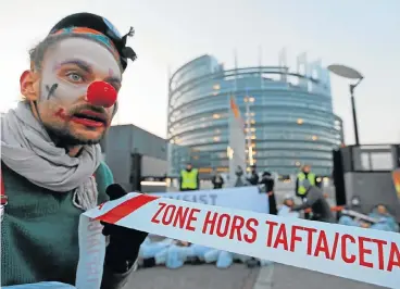  ?? /Reuters ?? No laughing matter: A demonstrat­or dressed as a clown holds a banner as he takes part in a protest against the Comprehens­ive Economic Trade Agreement between the EU and Canada in front of the European Parliament in Strasbourg, France, on Wednesday.