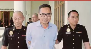  ?? PIC BY SHARUL HAFIZ ZAM ?? Putrajaya Community Developmen­t Department director Mohd Adnan Md Daud being led to the Sessions Court in Alor Star yesterday.