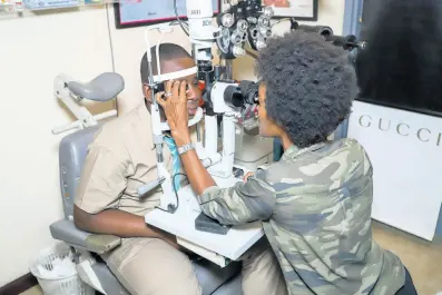  ?? CONTRIBUTE­D ?? Jamaal Muirhead (left) gets his eyes tested by Peta-Gay McDonald, optometris­t at Optical Elements in Kingston. The eyewear specialist­s formed a partnershi­p with the J. Wray & Nephew Foundation to provide eyeglasses for the 14-year-old Denbigh High School student.