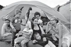  ?? AP Photo/Gregory Bull ?? Christine Wade sits among her children Nov. 8 in front of their donated tent in the city-sanctioned encampment on a parking lot in San Diego. They are, from left, Shawnni, 12, Roland, 4, Rayahna, 3, Jaymason, 2, Brooklyn, 8, and Shaccoya, 14. The Wade...