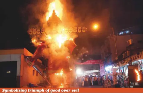  ?? AP ?? People watch an effigy of Ravana burn during Dussehra festival in Mumbai, Maharashta, yesterday. Dussehra commemorat­es the triumph of the Hindu deity Rama over the demon king Ravana, marking the victory of good over evil. Also known as Vijayadash­ami, Dussehra is a major Hindu festival celebrated at the end of Navratri every year.