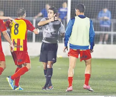  ?? MANUEL ARANDA ?? El colegiado del XCD-Lleida suspendió media hora el partido por lanzamient­os de objetos desde fuera de La Granja.