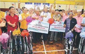  ??  ?? Ismail Sabri (centre) and FELCRA settlers give their thumbs-up following the interim dividend distributi­on ceremony on Sunday