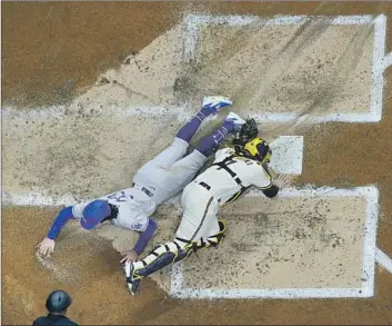  ?? Morry Gash Associated Press ?? THE DODGERS’ James Outman beats the tag from Brewers catcher Victor Caratini and scores in the second inning. Outman had doubled and came home on Miguel Rojas’ two-out single to right field.