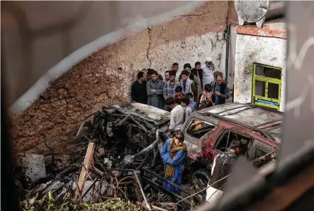  ?? Photos by Jim Huylebroek / New York Times ?? People gather Aug. 30 near remnants of a vehicle destroyed by a U.S. drone strike that occurred a day earlier in Kabul, Afghanista­n. Aid worker Zemari Ahmadi and seven children from his extended family were killed in the explosion.