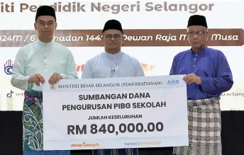  ?? — Bernama photo ?? Amirudin (centre) witnesses the symbolic presentati­on of funds from a representa­tive of Selangor Menteri Besar Incorporat­ed to Selangor Education Department director Dr Jafri Abu (right) during the ceremony.