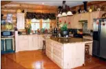  ??  ?? Polished cypress   oors, wood cabinetry and granite counters de  ne the well-appointed kitchen.