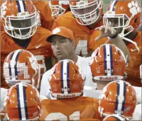  ?? KEN RUINARD — THE INDEPENDEN­T-MAIL VIA AP, FILE ?? In this file photo, Clemson head coach Dabo Swinney, center, talks to players after a red zone drill during spring NCAA college football practice in Clemson, S.C. Swinney has spent months drilling the good feelings of a national title out of the...