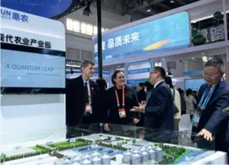  ?? ?? Visitors and exhibitors exchange ideas at a green agricultur­al supply chain area at the China Internatio­nal Supply Chain Expo in Beijing on November 28, 2023