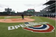  ?? The Associated Press ?? ■ A member of the grounds crew prepares home plate before the Chicago Cubs home-opener against the Milwaukee Brewers Thursday in Chicago.