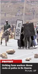  ?? PICTURE: AP ?? PROTEST Striking farm workers throw rocks at police in De Doorns