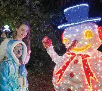  ??  ?? Victoria Letheby (back) and Isabel Graham admire a snowman at Toowoomba's Christmas Wonderland.