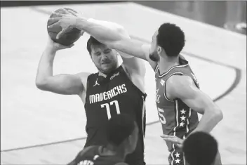  ?? TONY GUTIERREZ/AP ?? DALLAS MAVERICKS GUARD LUKA DONCIC (77) works to keep control of the ball against Philadelph­ia 76ers guard Ben Simmons (25) in the first half of an NBA game in Dallas on Monday.