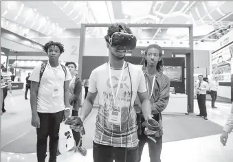  ?? -AP ?? A visitor tries a virtual reality headset during an expo in China.