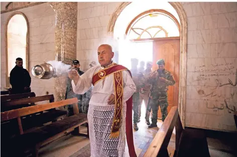  ?? FOTO: AP ?? Christlich­e Milizionär­e schützen den Ostergotte­sdienst im nordirakis­chen Karakosch. Die Terrormili­z IS hatte nach 2014 viele Einwohner der Stadt vertrieben. Und noch immer lebt etwa die Hälfte der Christen aus der Region im Exil.