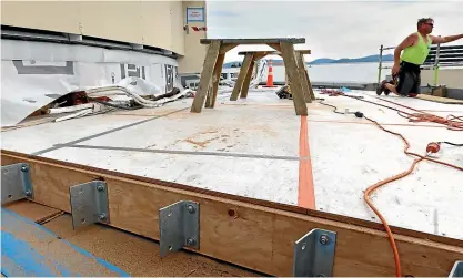  ?? PHOTOS: CHLOE RANFORD/LDR ?? A tradesman works on the first of 12 roof sections being built on top of the existing 46-year-old roof.