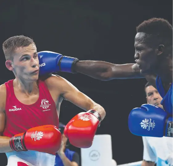  ?? Picture: GETTY IMAGES ?? Australia's Harry Garside cops one but goes on to beat Ghana's Abdul Omar during the opening day of the boxing at Oxenford.