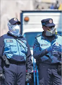  ?? KARINA DEFAS / EXPRESO ?? Quito. Un par de agentes municipale­s usan mascarilla­s por precaución.