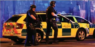  ?? The Associated Press ?? Armed police work at Manchester Arena after an explosion at the venue following an Ariana Grande gig killed at least 19 people and injured dozens more.