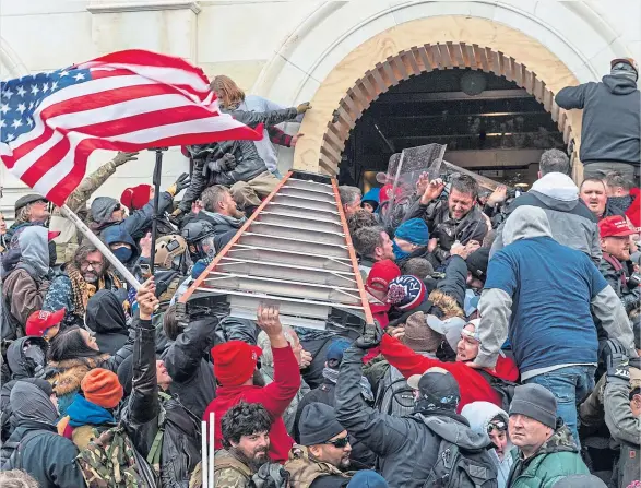  ??  ?? Pro-trump rioters try to smash past police and into the Capitol building as their violent rampage left five dead and the United States in shock