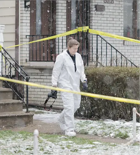  ?? DAX MELMER ?? An officer with the Windsor police forensics unit investigat­es at 924 Elsmere Ave. after a man died of gunshot wounds early Saturday. Police said the suspect and the victim knew each other.