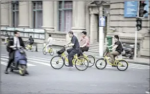  ?? Bloomberg News/QILAI SHEN ?? Commuters ride Ofo Inc. bicycles along a sidewalk in Shanghai last week.