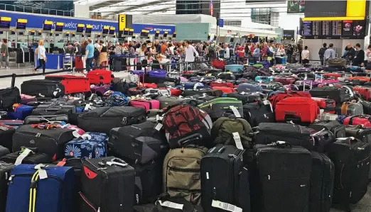  ??  ?? Pile up: Hundreds of bags were left behind a cordon at Heathrow’s Terminal 5 after all BA’s flights were cancelled