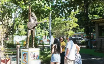  ?? REUTERS/Gilbert Bellamy ?? Tourists view a statue of Bob Marley outside the Bob Marley Museum in Kingston December 13, 2013.