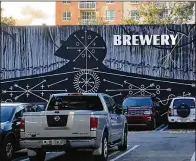  ?? TONY DORIS / THE PALM BEACH POST ?? Havana-born artist Jose Bedia’s mural on Evernia Street now has an illuminate­d “Brewery” sign attached to it, which has upset the artist and his father-manager.