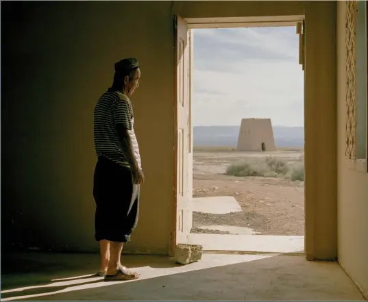  ??  ?? June 2016. A Uyghur man looks through the door of his house into the Turpan depression and the dried-up Ayding Lake. At 154 metres below sea level, it’s the lowest point in China. This man is the guardian of the site and lives here year-round, mostly by himself with his two camels and one donkey, receiving food and water supplies on a weekly basis.