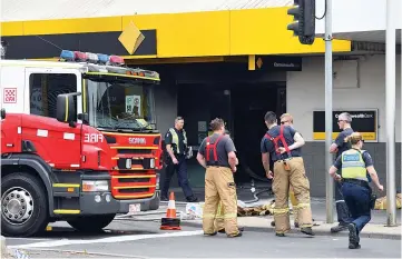  ??  ?? Emergency service workers are seen at a branch of the Commonweal­th Bank after a fire injured customers in Melbourne. — Reuters photo