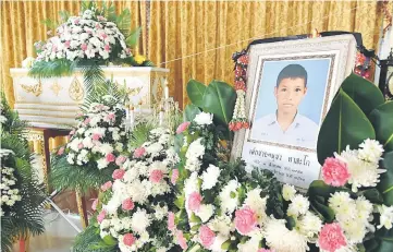  ??  ?? A portrait of 13-year-old Muay Thai boxer Anucha Tasako is displayed next to his coffin during a funeral at a Buddhist temple in Samut Prakan province. — AFP photo