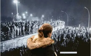  ?? Foto: Paul Zinken, dpa ?? Blick zurück auf den historisch­en Moment – aus der aktuellen Berliner Open-Air-Ausstellun­g zum Mauerfall.